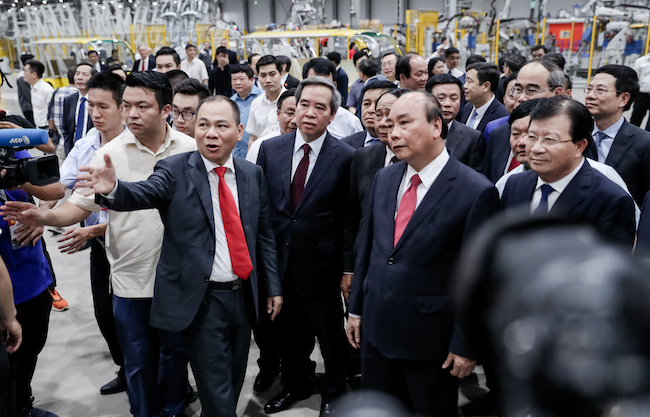 Chủ tịch Tập đoàn Vingroup Phạm Nhật Vượng giới thiệu với Thủ tướng Nguyễn Xuân Phúc về Nhà máy sản xuất ô tô VinFast tại lễ khánh thành