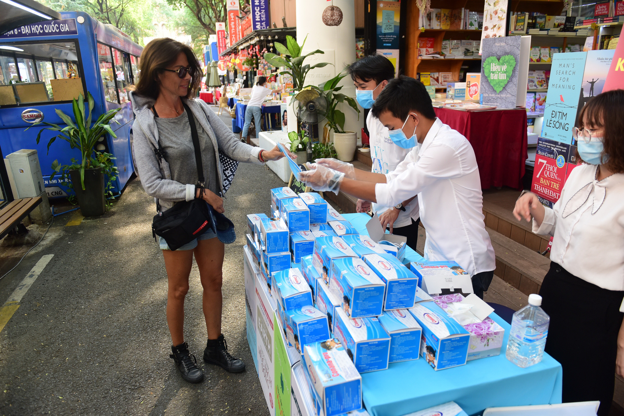 Du khách nước ngoài nhận khẩu trang miễn phí tại đường sách Nguyễn Văn Bình, quận 1, TPHCM - Ảnh: QUANG ĐỊNH