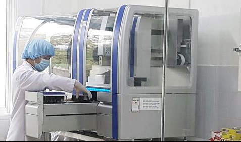 Kỹ thuật viên của CDC Quảng Nam thực hiện xét nghiệm trên hệ thống xét nghiệm Realtime PCR - Ảnh: TTO