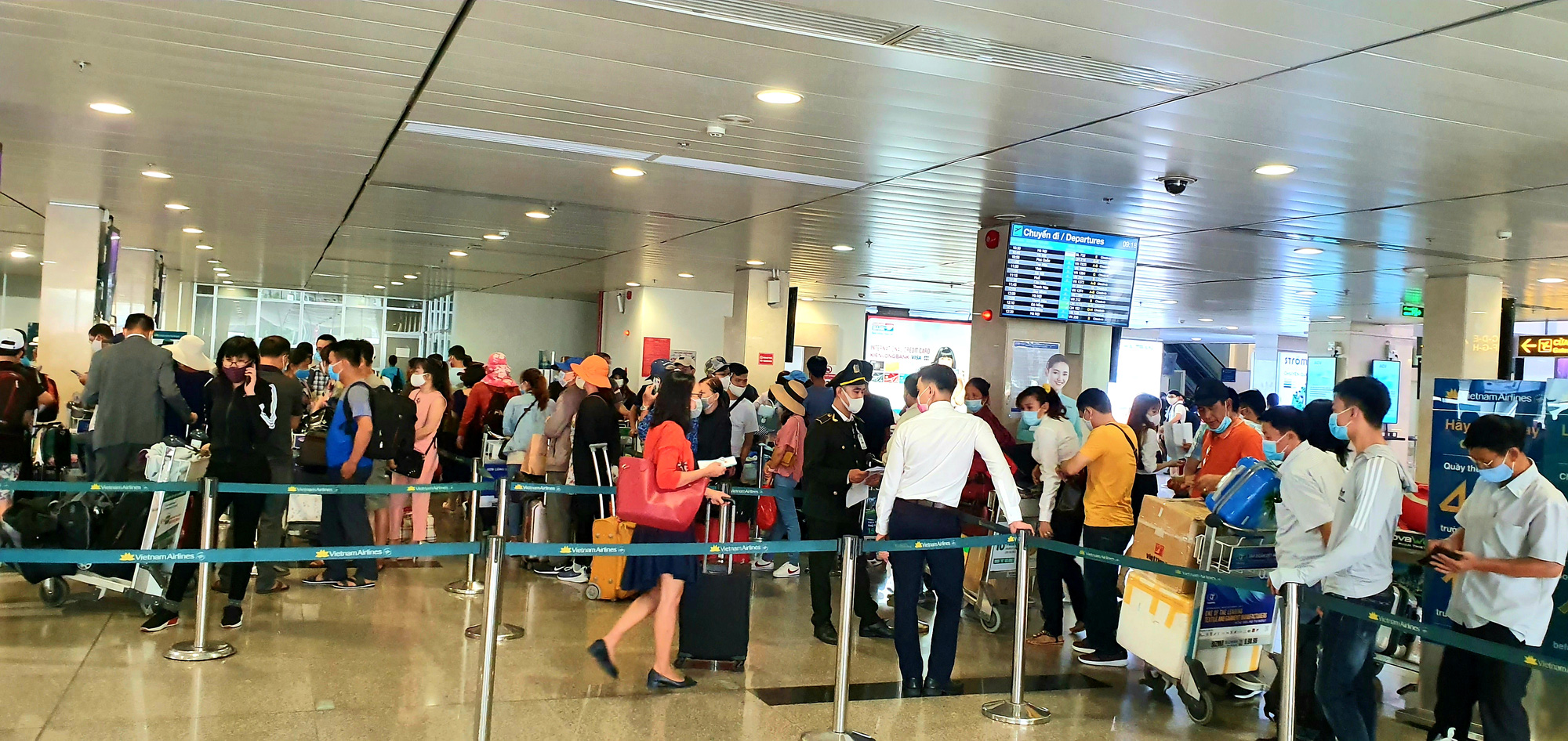 Hành khách xếp hàng chờ làm thủ tục check-in của Vietnam Airlines tại Tân Sơn Nhất vào sáng 10-6 - Ảnh: CÔNG TRUNG