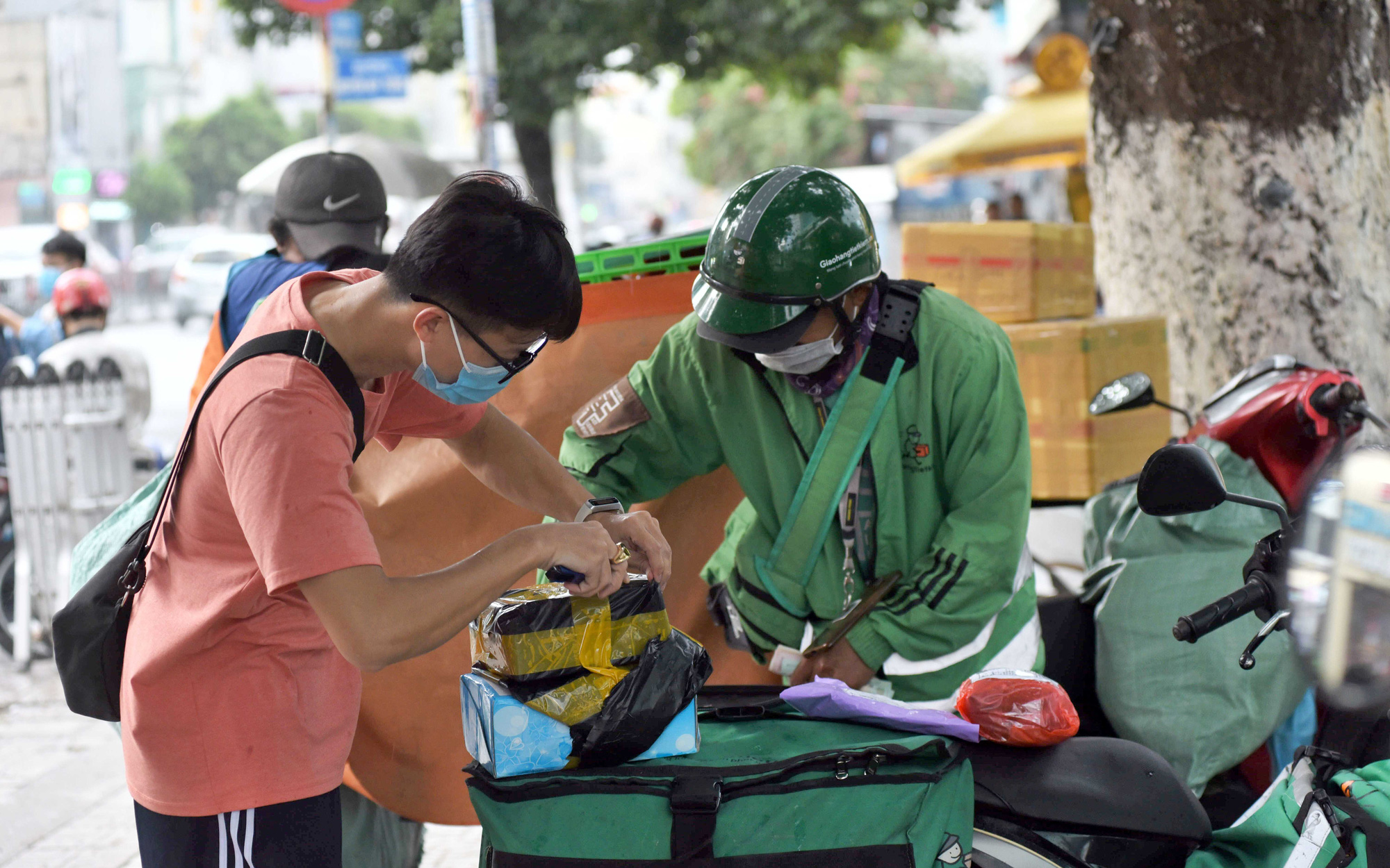 Anh Duy (Q.Bình Thạnh, TP.HCM) kiểm tra hàng trước khi nhận từ nhân viên giao hàng - Ảnh: DUYÊN PHAN